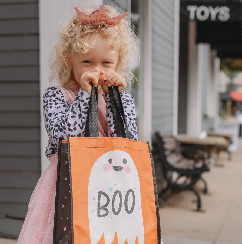 girl holding up halloween bag